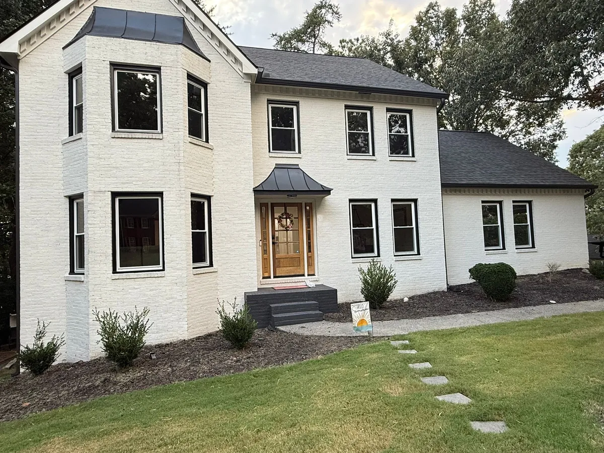Black double hung windows on a painted white brick home