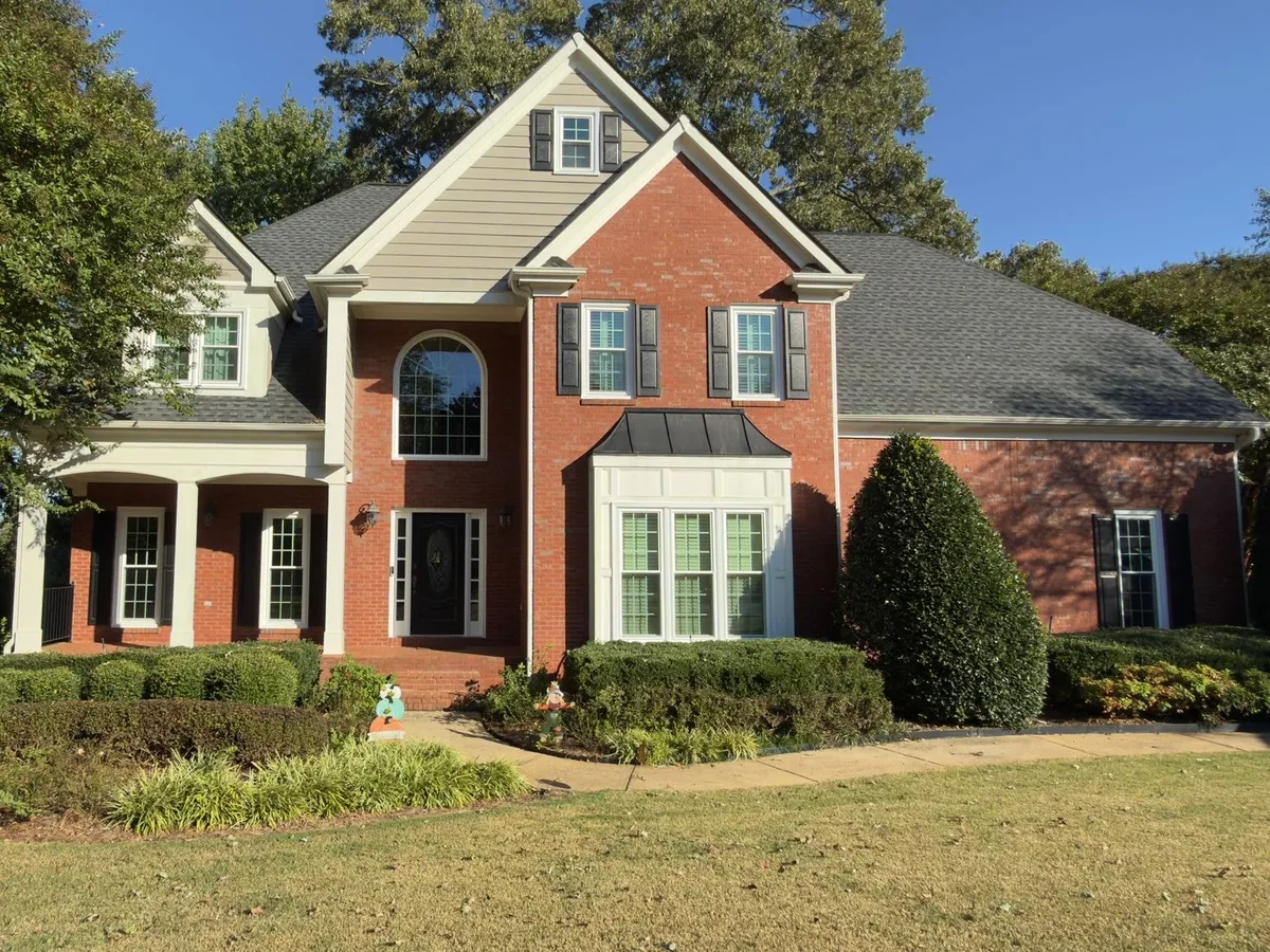 Double hung windows, a box bay and an arched window on a brick home