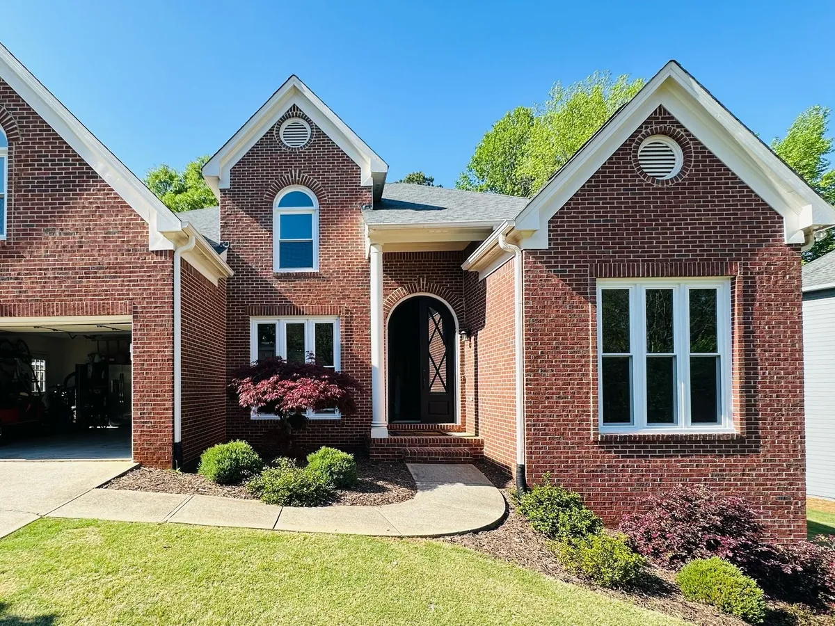 Arched windows and a tall triple window on a brick home