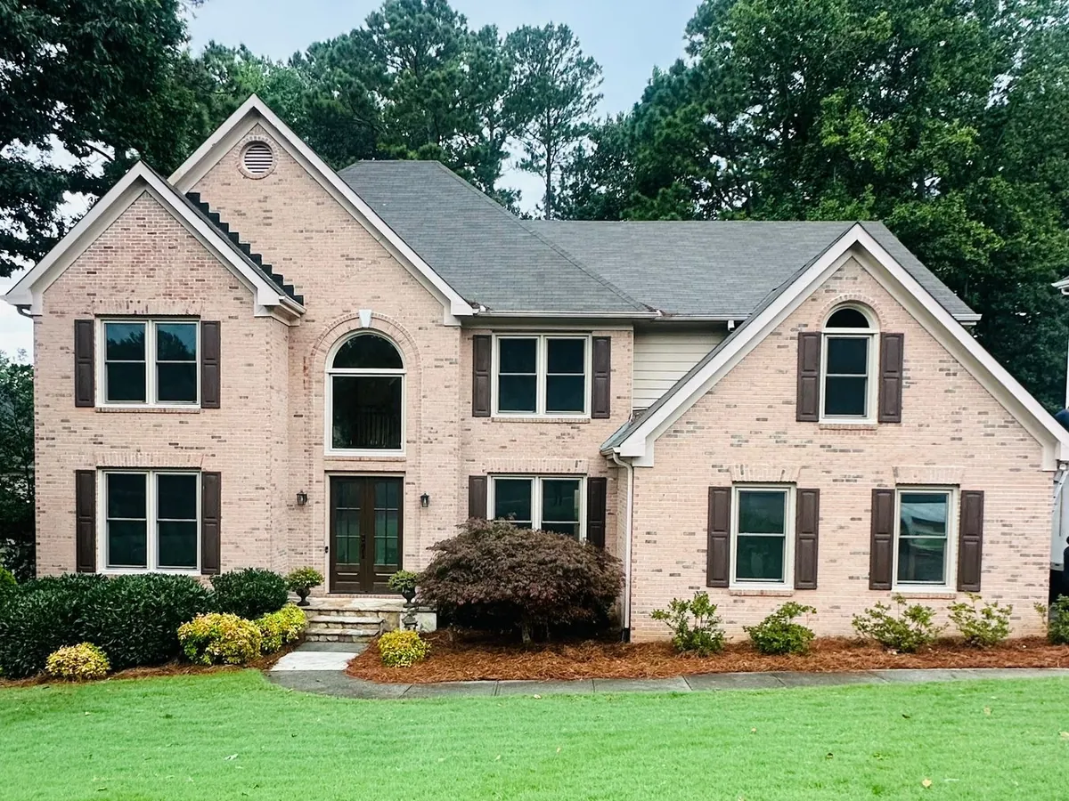Double hung windows with grids and an arched window on a light brick colonial